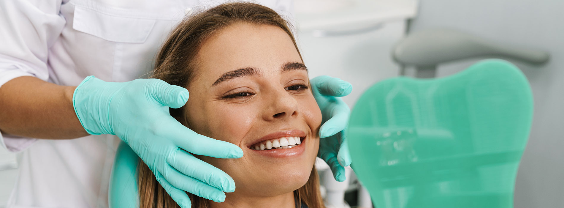 The image shows a woman receiving dental care, with her head in a dentist s chair, being examined by a dental professional.