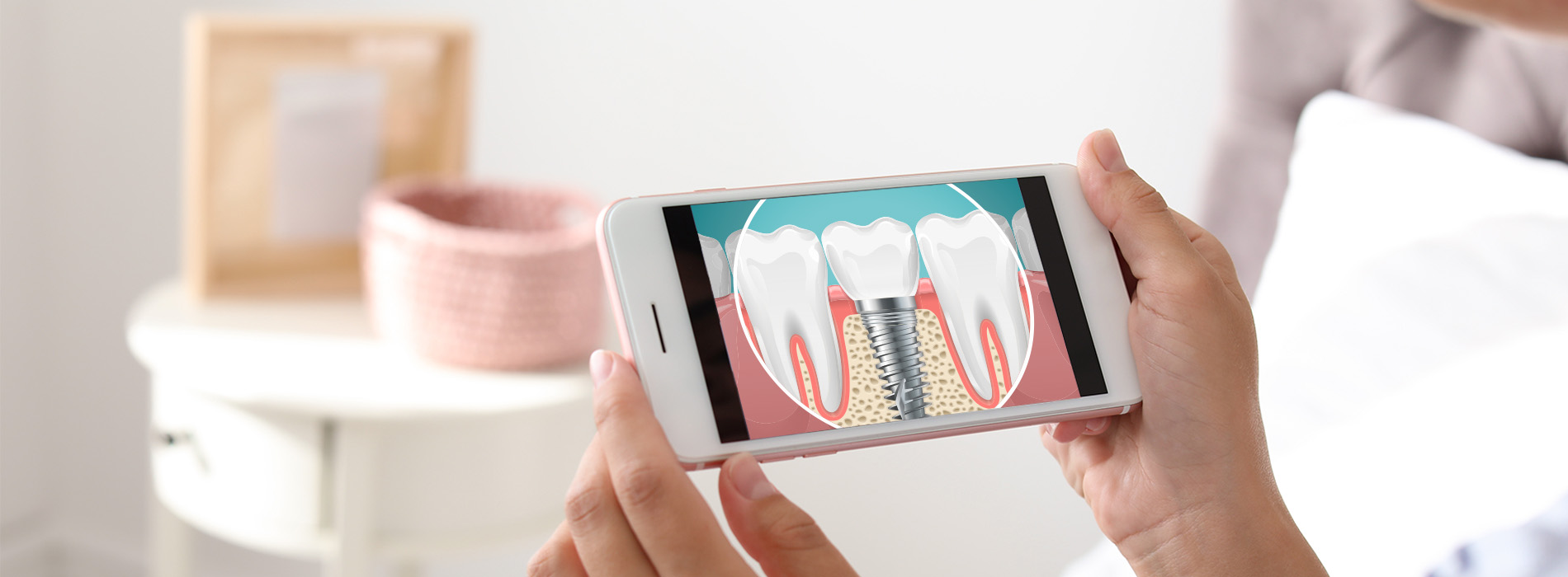 A person holding a smartphone displaying dental care products while sitting at a table with a cup on it.