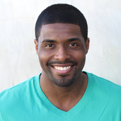 An elderly couple posing closely together with smiles on their faces.