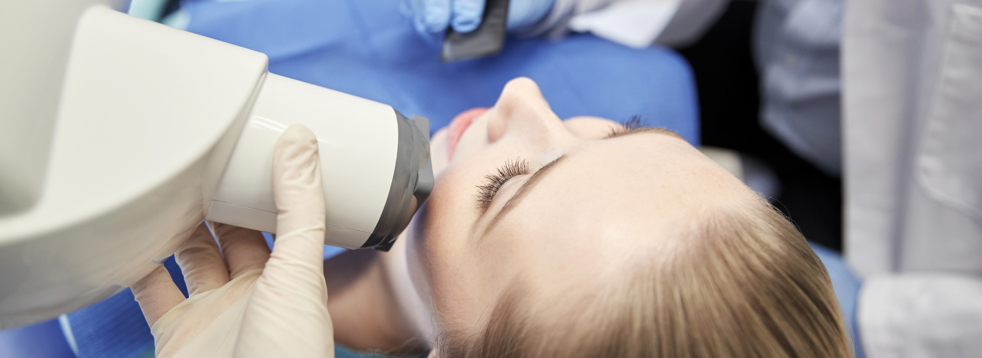 An individual receiving dental care with a focus on the dental device used during the procedure.
