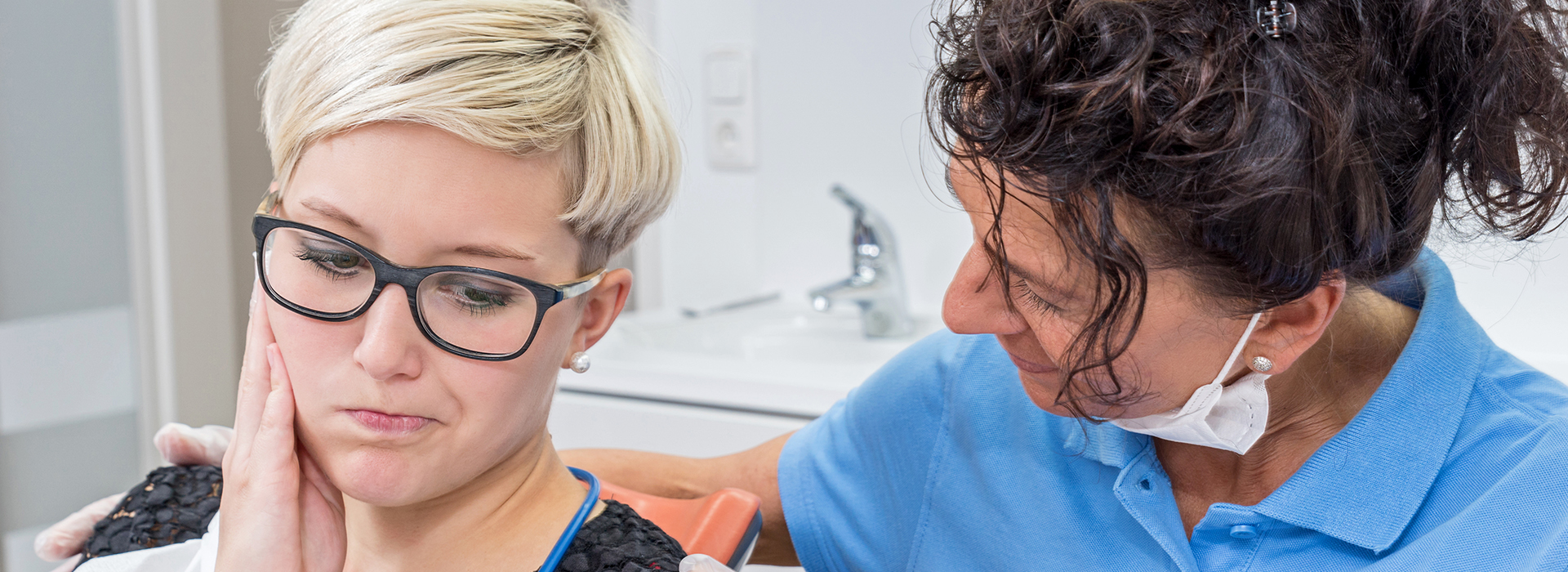 The image shows a dental professional attending to a patient s teeth in an office setting.