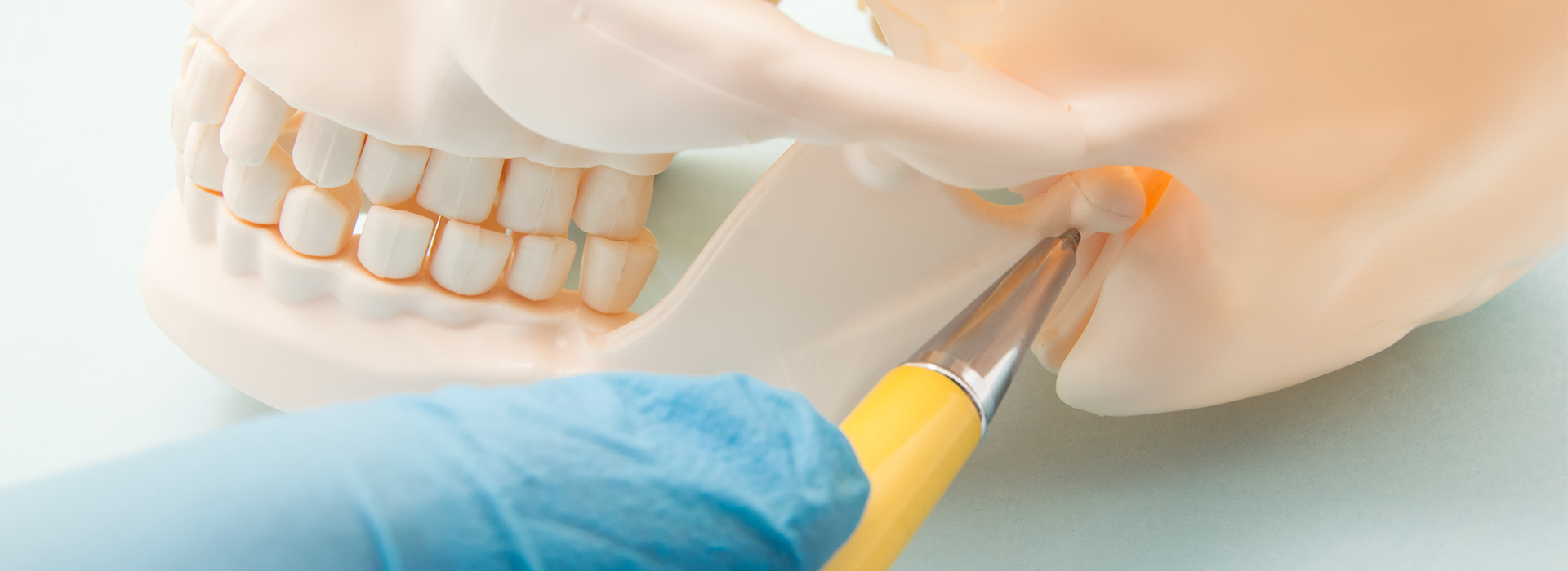 The image shows a close-up view of a dental implant procedure with a toothbrush being used by a person s hand, which is visible at the bottom of the frame.
