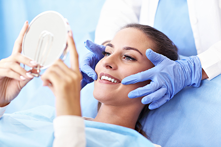 An individual undergoing a medical procedure with a magnifying glass placed on their head by a healthcare professional.