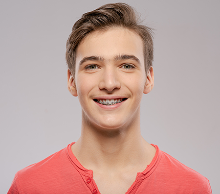 The image shows two side-by-side photographs of a young man with a bright smile, wearing red shirts and posing against a white background.