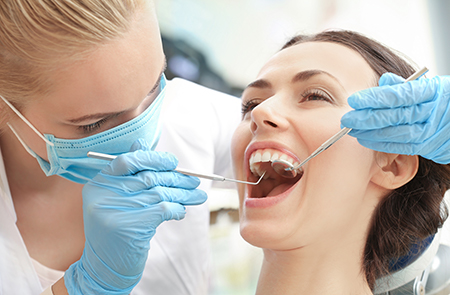 A dental hygienist performing oral care on a patient in a dental office.